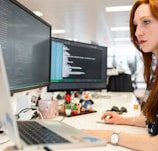 woman in green shirt sitting in front of computer